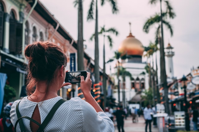 woman taking a photo of a beautiful scenery using her phone 