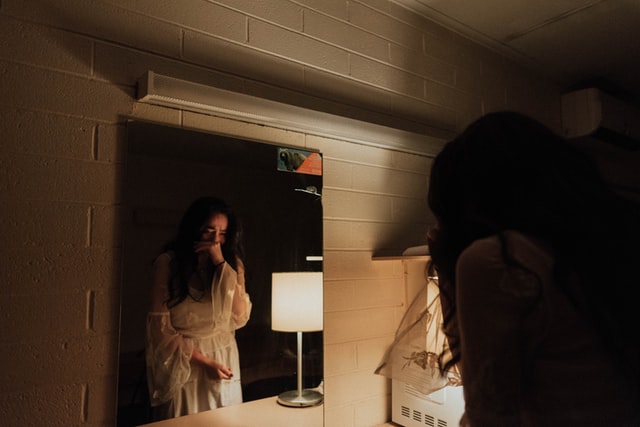 woman crying facing the mirror 