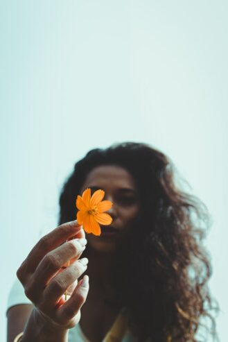 woman holding flower in her hand 