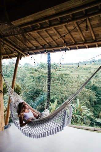 female traveler resting in hammock while contemplating with nature