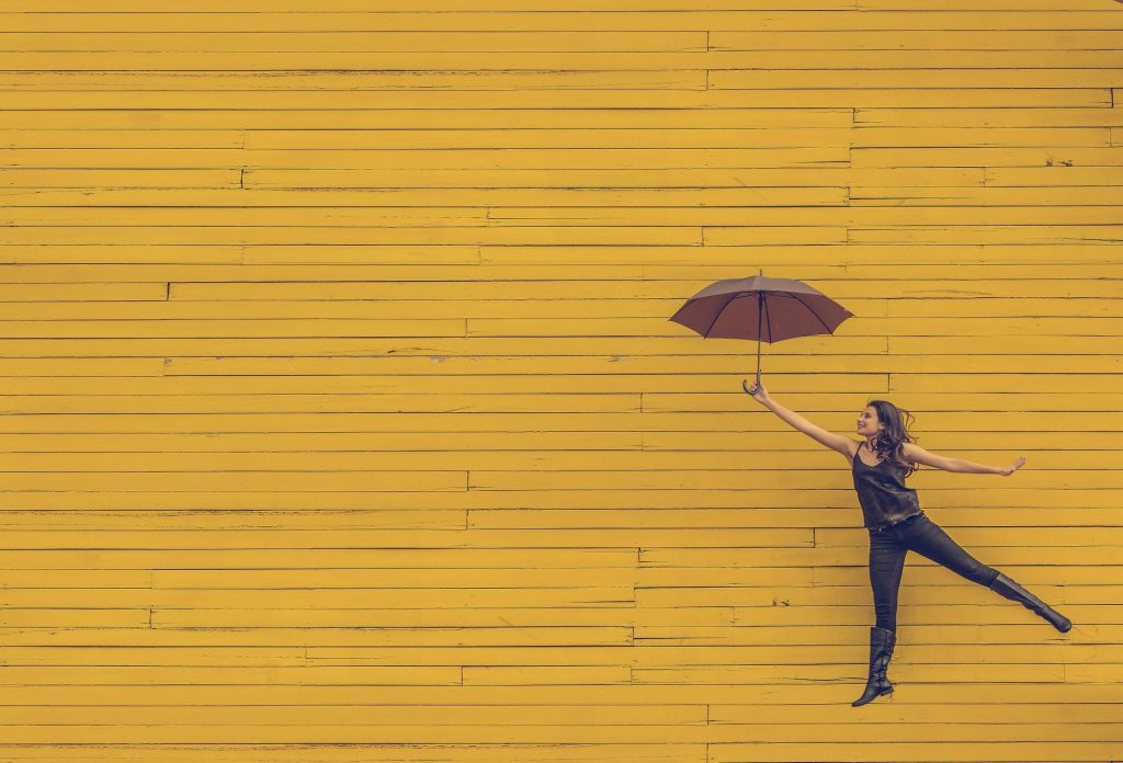 jumping woman holding an umbrella