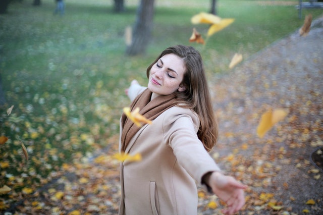 woman in open arms smiling while eyes are close