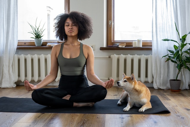 woman meditating with her dog 