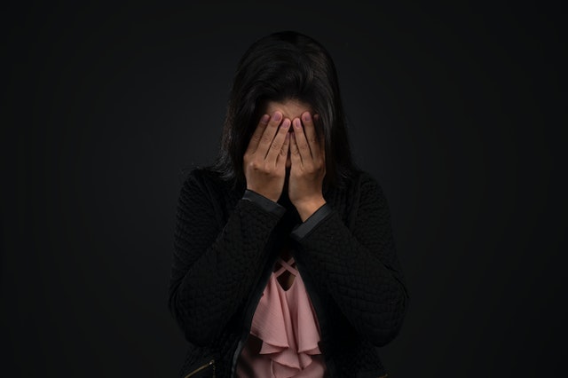 anonymous upset woman covering her face
