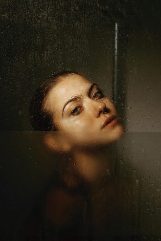 woman behind glass wall in shower cabin