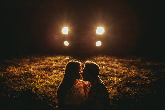 romantic young couple cuddling during date in countryside at night