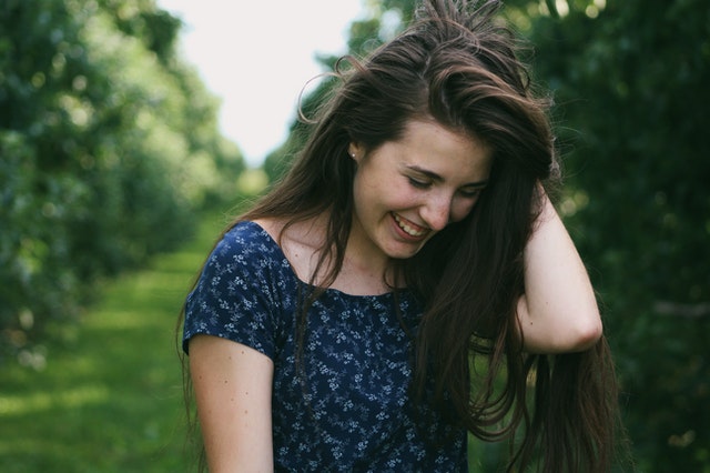 woman holding her hair smiling 
