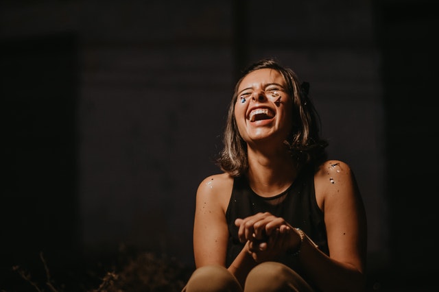 woman laughing wearing black top