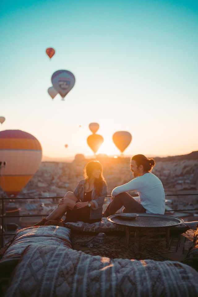 couple sitting on rooftop during sunset