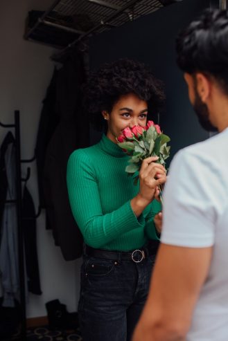 women smelling the fresh roses given by her man 