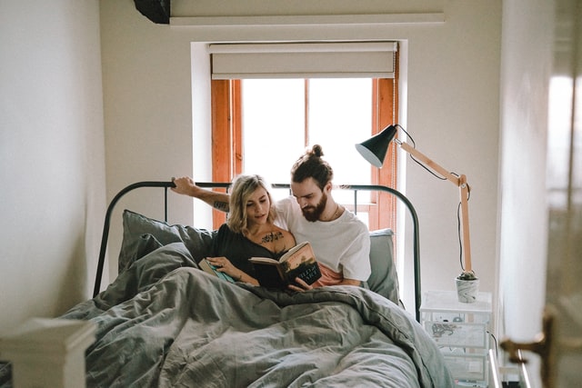 couple reading book in the bed 